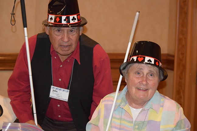 John Arroy and Ramona Walhof wear top hats while taking tickets at the Broken Spectacles concert